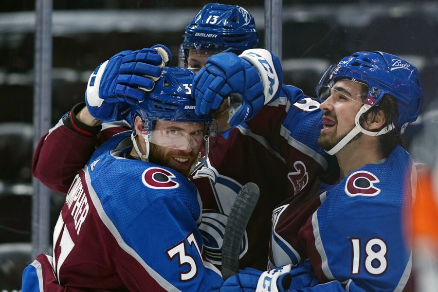 Colorado Avalanche left wing J.T. Compher (37) is congratulated by teammates Valeri Nichushkin (13) and Alex Newhook (18) after scoring a hat trick against the Los Angeles Kings during the second period of an NHL hockey game Wednesday, May, 12, 2021, in Denver. (AP Photo/Jack Dempsey)