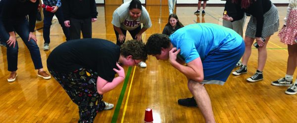 The Cup Game. Emma Mathis and Issac Turner stand off in one of the many Impact One games. When playing, these two had to hold certain positions until the person in charge said “cup.” “The cup game is definitely one of the most competitive games that you can play at Impact One,” BHS junior Aleah McGraw said.