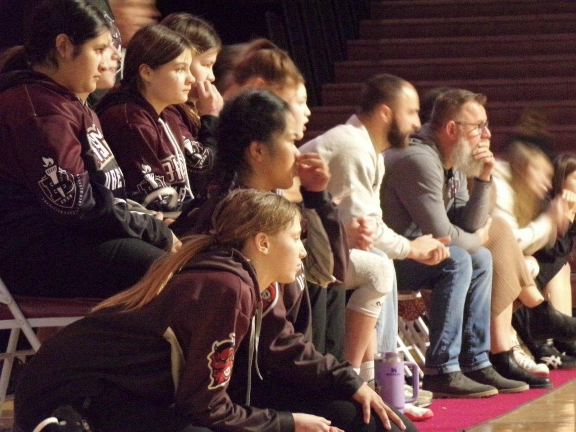 Sidelines.+Bismarck+High%E2%80%99s+girls+wrestling+team+cheers+on+each+other+during+match-ups.+The+team+supports+each+other+and+creates+a+family+atmosphere+for+success.+%E2%80%9CI+absolutely+love+what+Ive+done+with+my+adult+life+and+my+career%2C%E2%80%9D+BHS+girls+wrestling+head+coach+Scott+Knowlen+said.+%E2%80%9CSeeing+the+wrestlers+achieve+their+goals+is+where+I+get+my+fulfillment.%E2%80%9D
